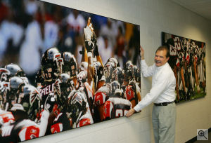Pete Casabonne, President of Myphotopipe.com, stands next to one of the company's 4,608-square-inch prints made for the Atlanta Falcons football team.